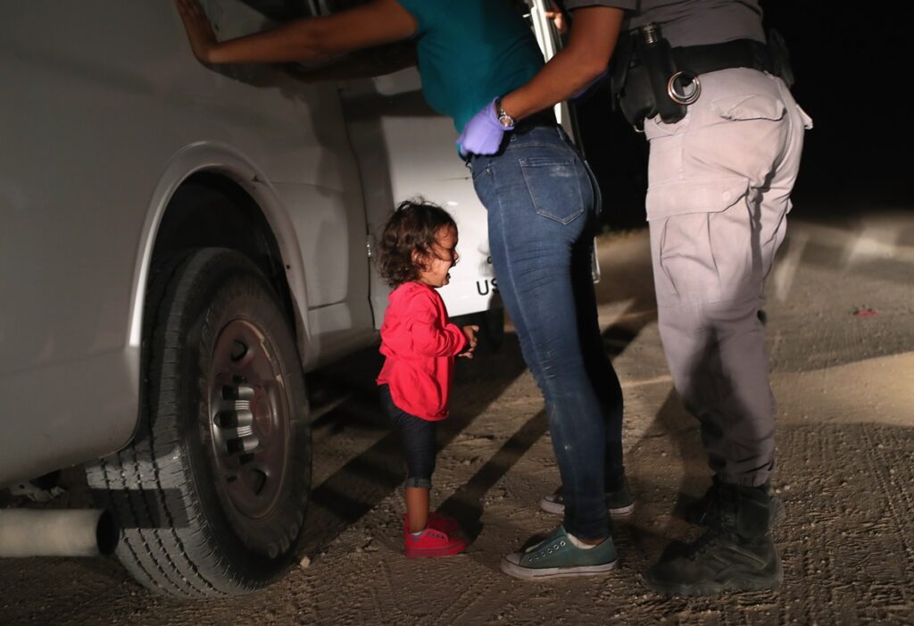 Een peuter en zijn moeder uit Honduras worden staande gehouden doorde grenspolitie bij McAllen, Texas, 12 juli 2018.