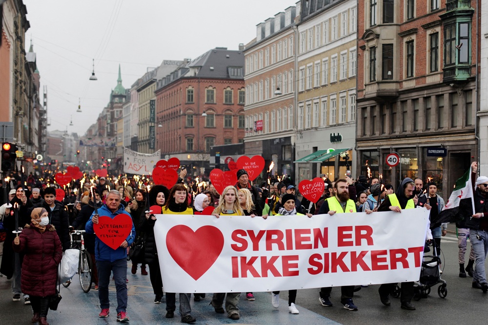 Demonstranten dragen een spandoek met de tekst ‘Syrië is niet veilig’ tijdens een protest tegen de uitzetting van Syrische families naar hun thuisland. Kopenhagen, 13 november 2021.